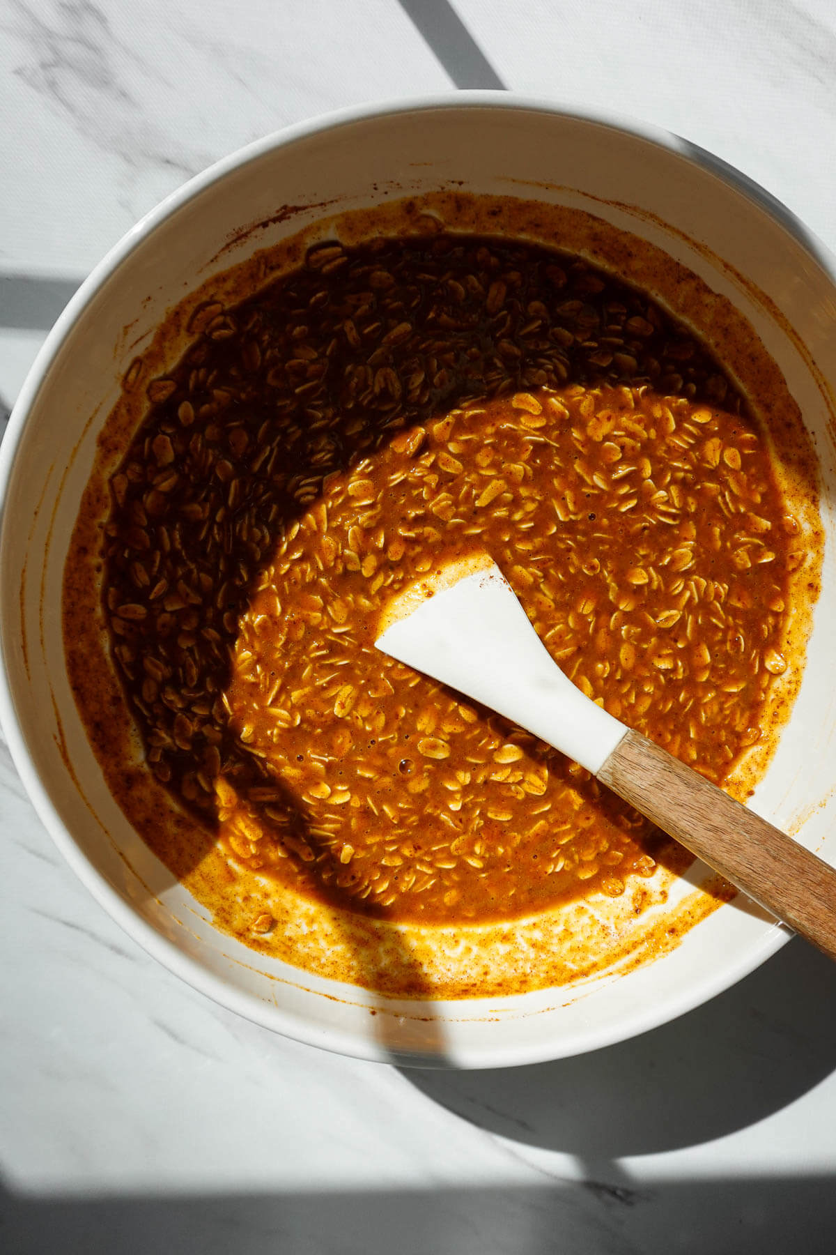 Pumpkin baked oatmeal ingredients mixed together in a bowl.