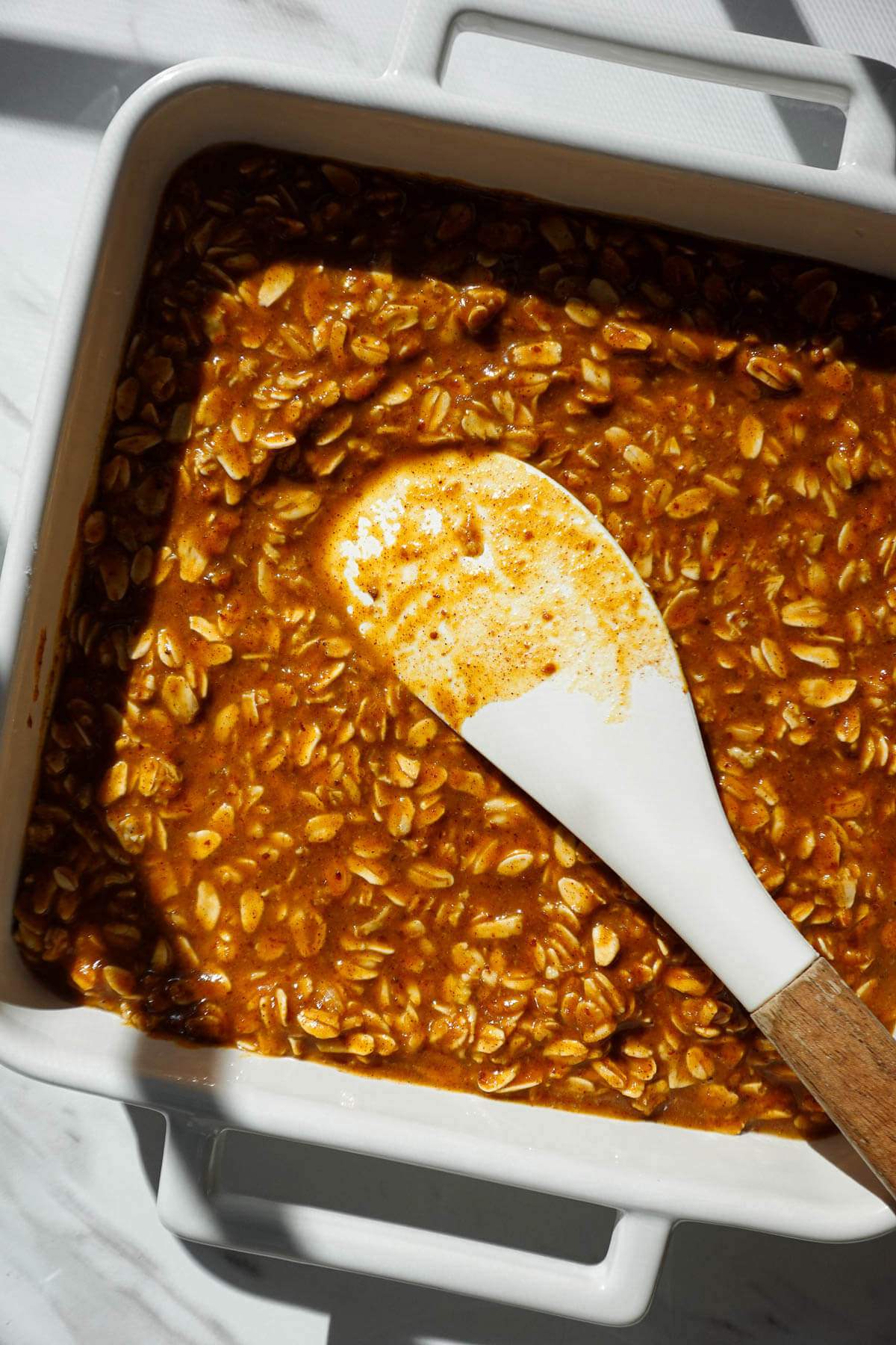 Pumpkin oatmeal mixture spread evenly in a greased baking dish.