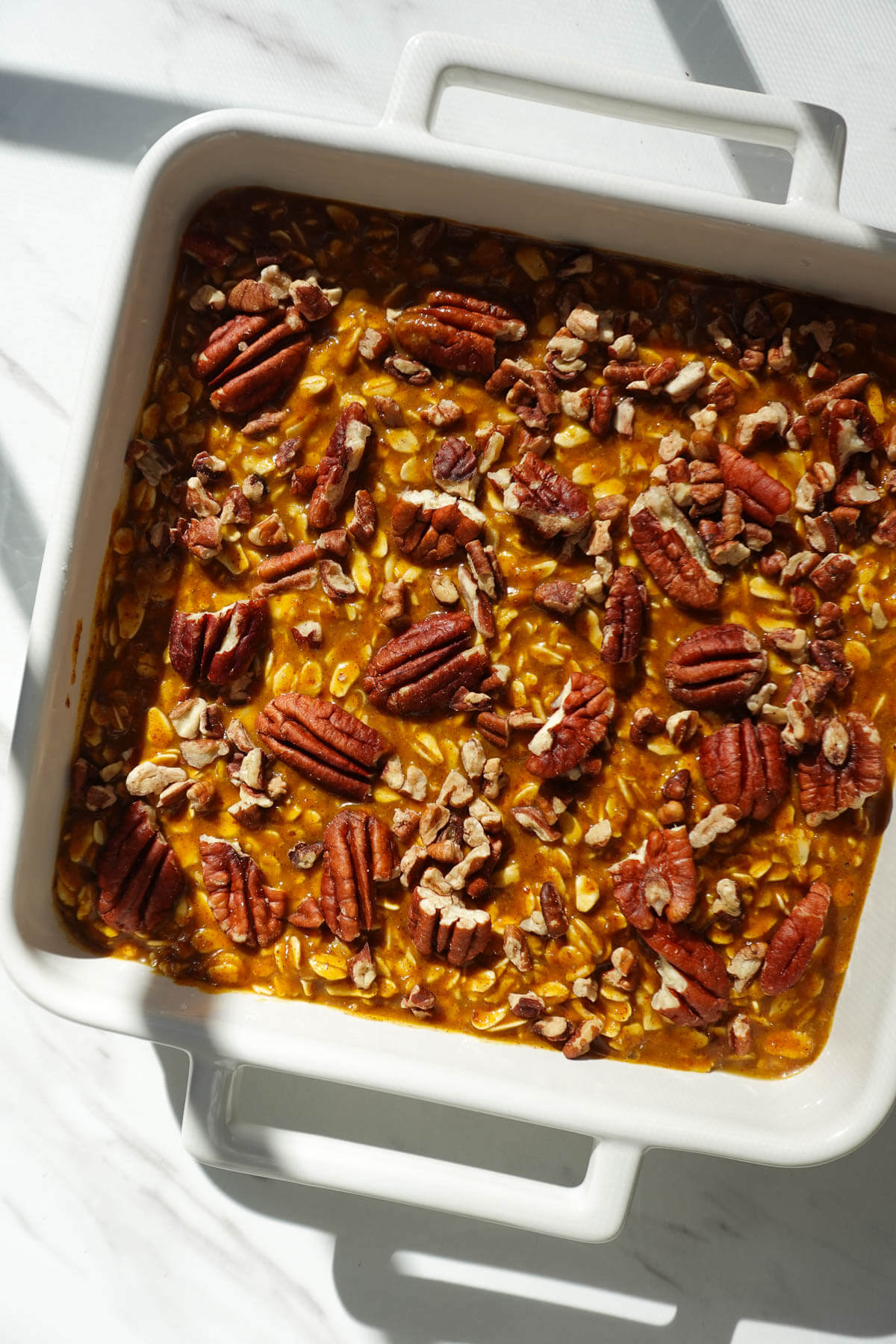 Pumpkin baked oatmeal topped with pecans before baking.