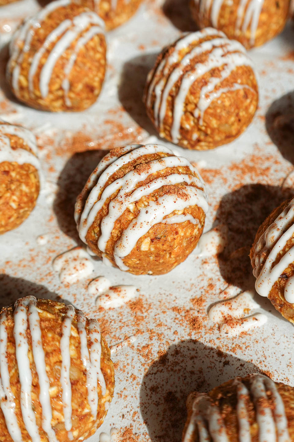 Pumpkin spice energy balls drizzled with vegan white chocolate and dusted with pumpkin spice.