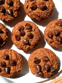 Healthy pumpkin muffins on a plate garnished with a cinnamon stick.
