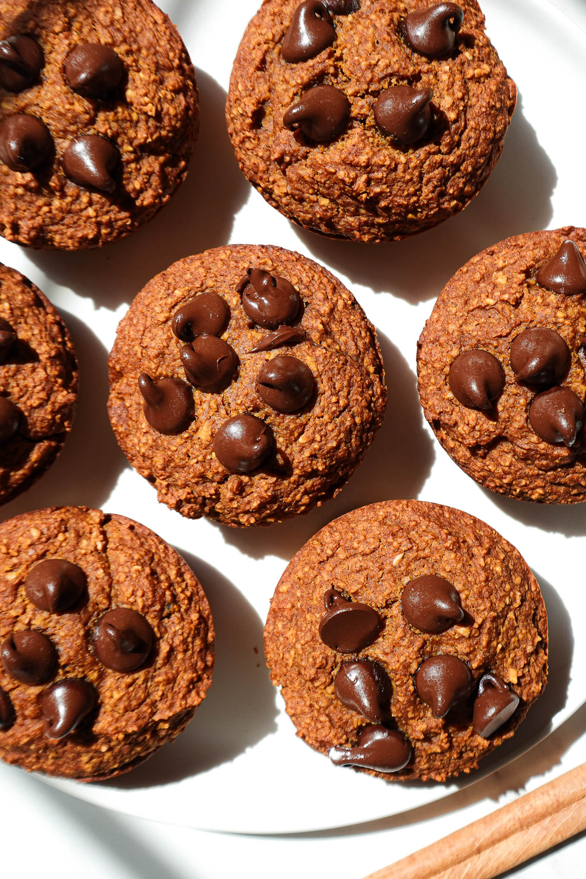 Healthy pumpkin muffins on a plate garnished with a cinnamon stick.