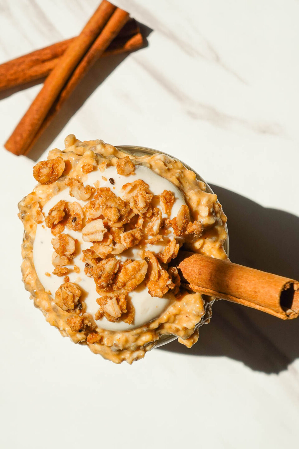 Overhead shot of vegan pumpkin overnight oats with yogurt swirl and crunchy granola