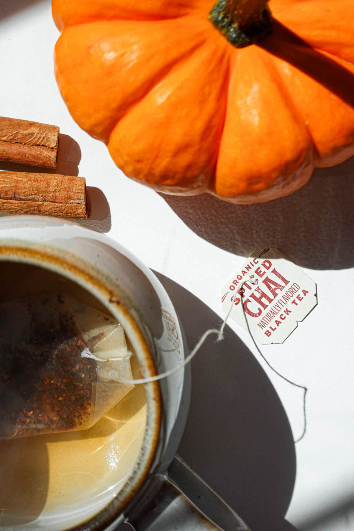 Chai tea bag steeping in hot water in a mug.