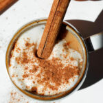 Overhead shot of my pumpkin spice chai tea latte with a cinnamon stick garnish on a fall-themed table setting