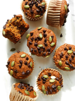Vegan pumpkin muffins topped with mini chocolate chips and pumpkin seeds.