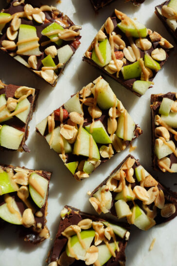 Caramel apple date bark topped with dark chocolate, diced green apple, peanut butter, and chopped peanuts.
