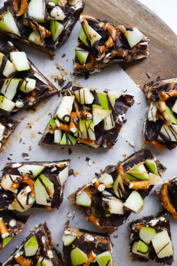 Finished caramel apple date bark cut into pieces and ready to be enjoyed, with a mix of sweet and salty toppings.