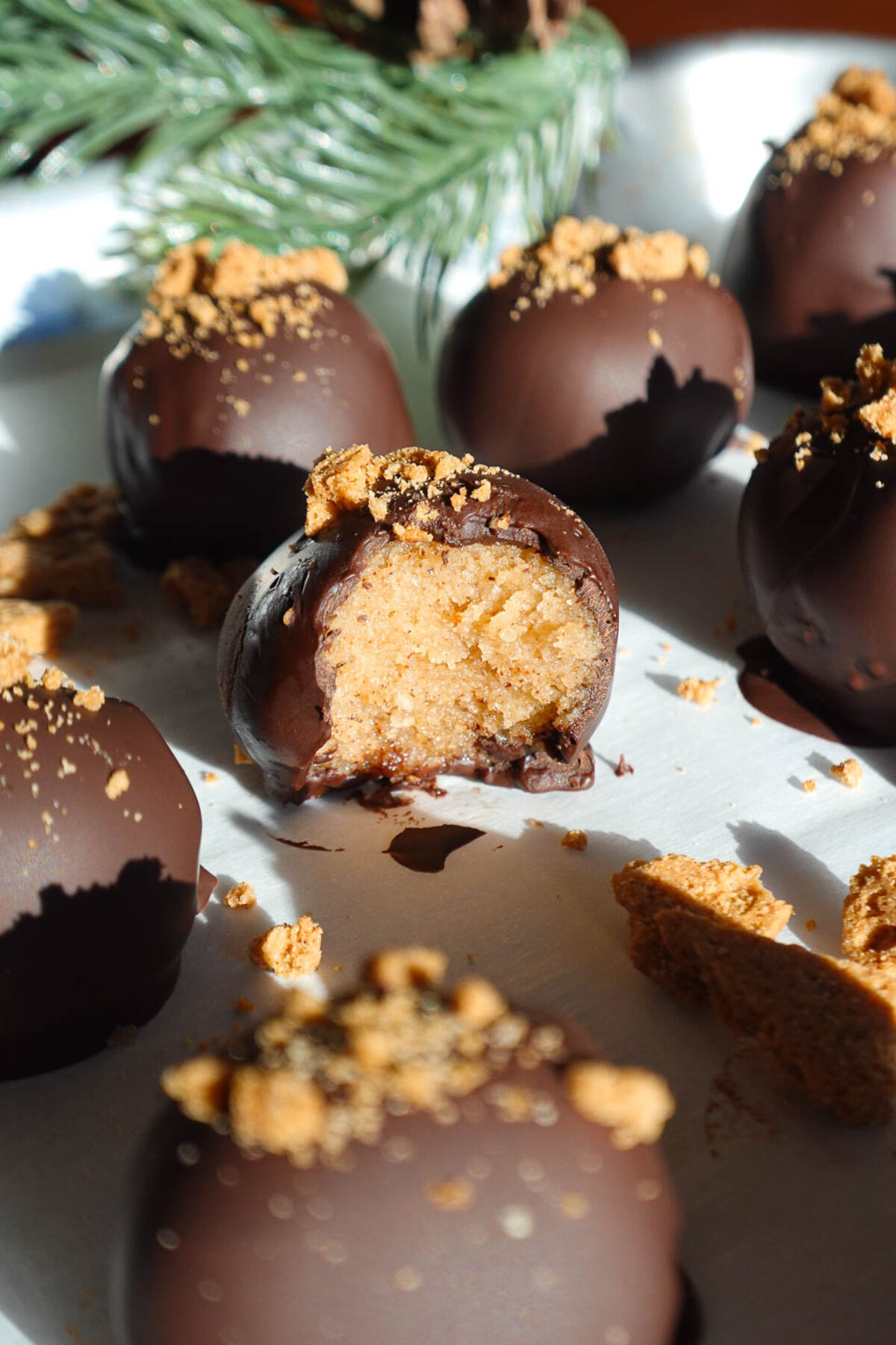Close-up of a vegan chocolate gingerbread truffle with a bite taken out, revealing the creamy texture inside.