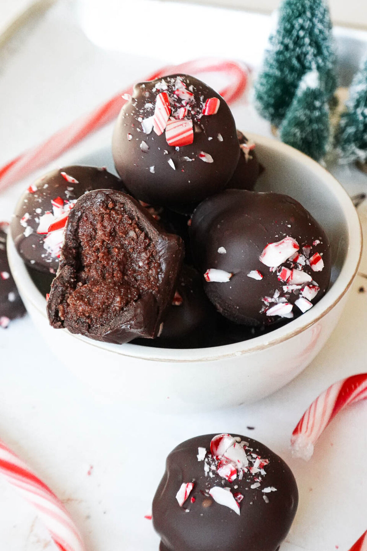Close-up of homemade chocolate peppermint truffles with a smooth texture and festive crushed candy cane topping.