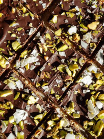 A close-up of broken pieces of chocolate quinoa bark, showing the layers of dark chocolate and crunchy nuts and seeds