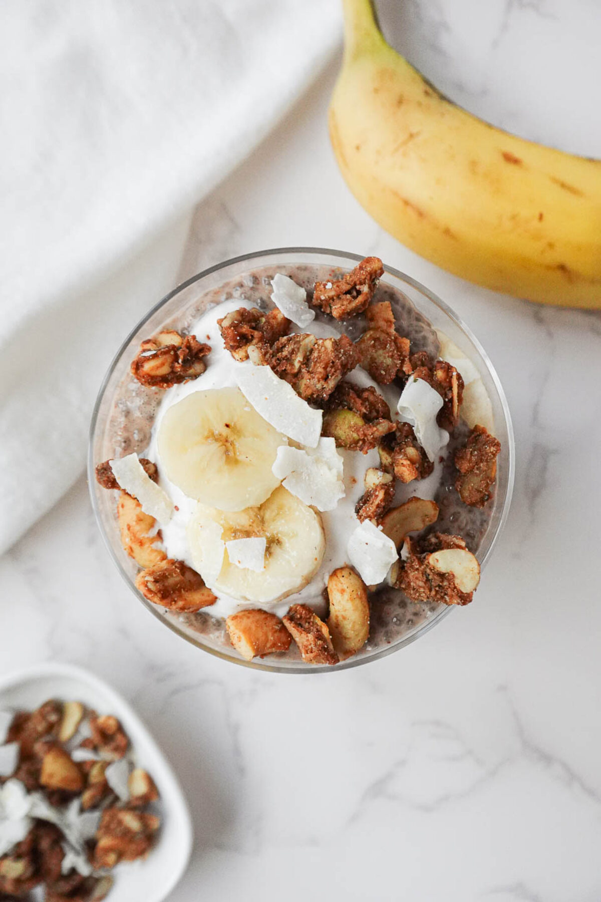 Healthy banana chia pudding topped with granola and fresh banana slices.