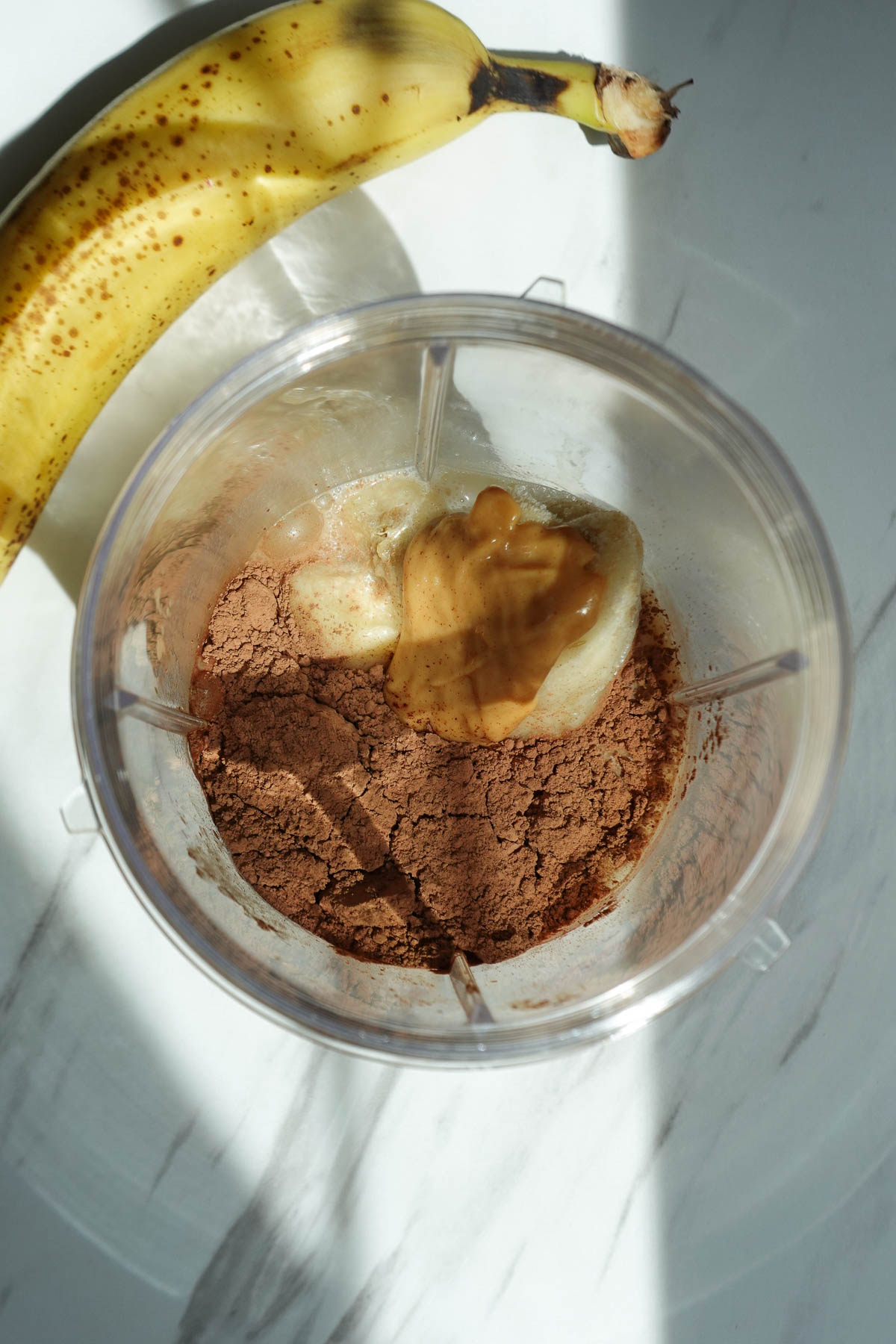 Chocolate banana smoothie ingredients in a high-speed blender.