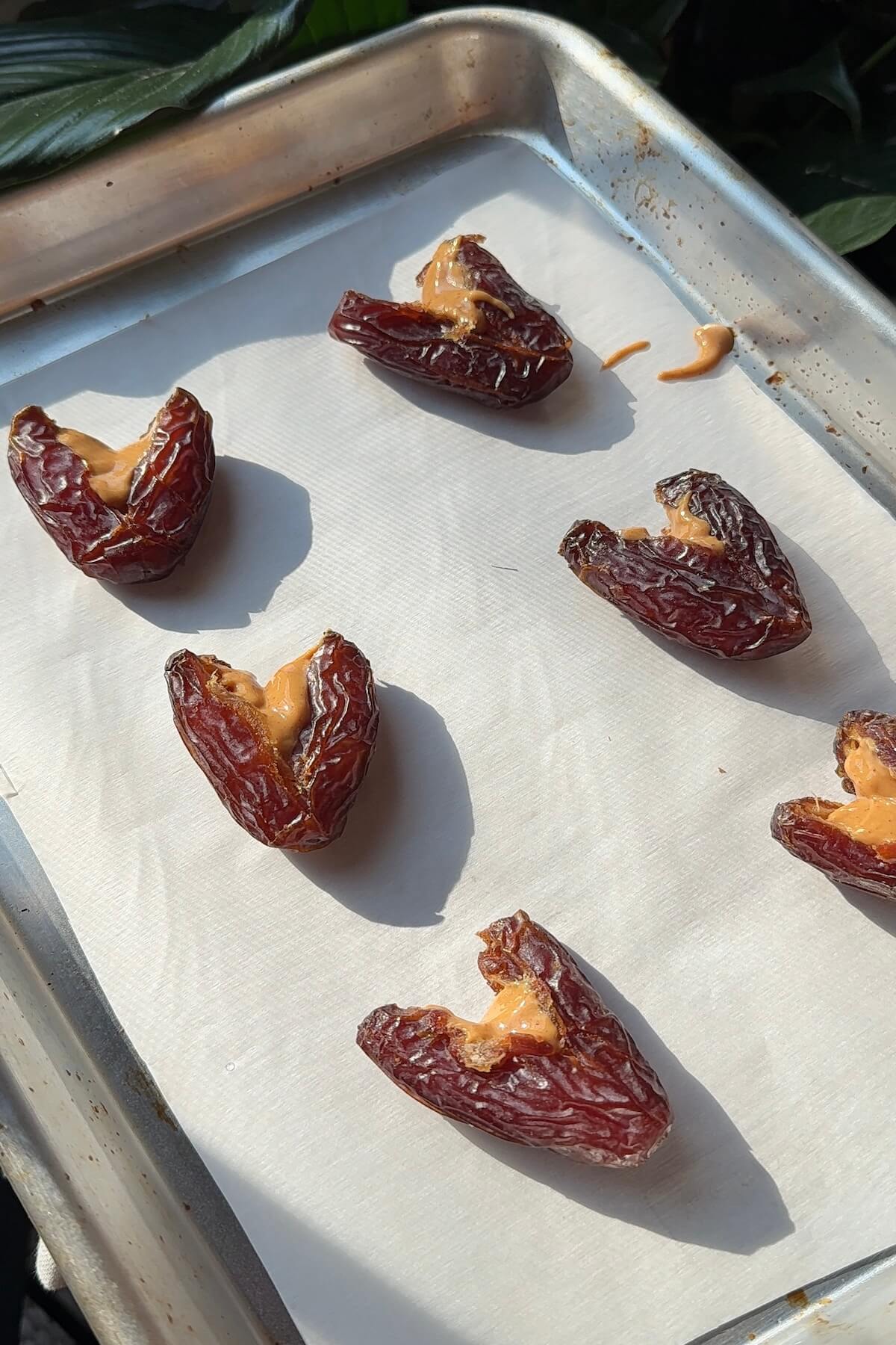 Filling heart-shaped medjool dates with peanut butter.