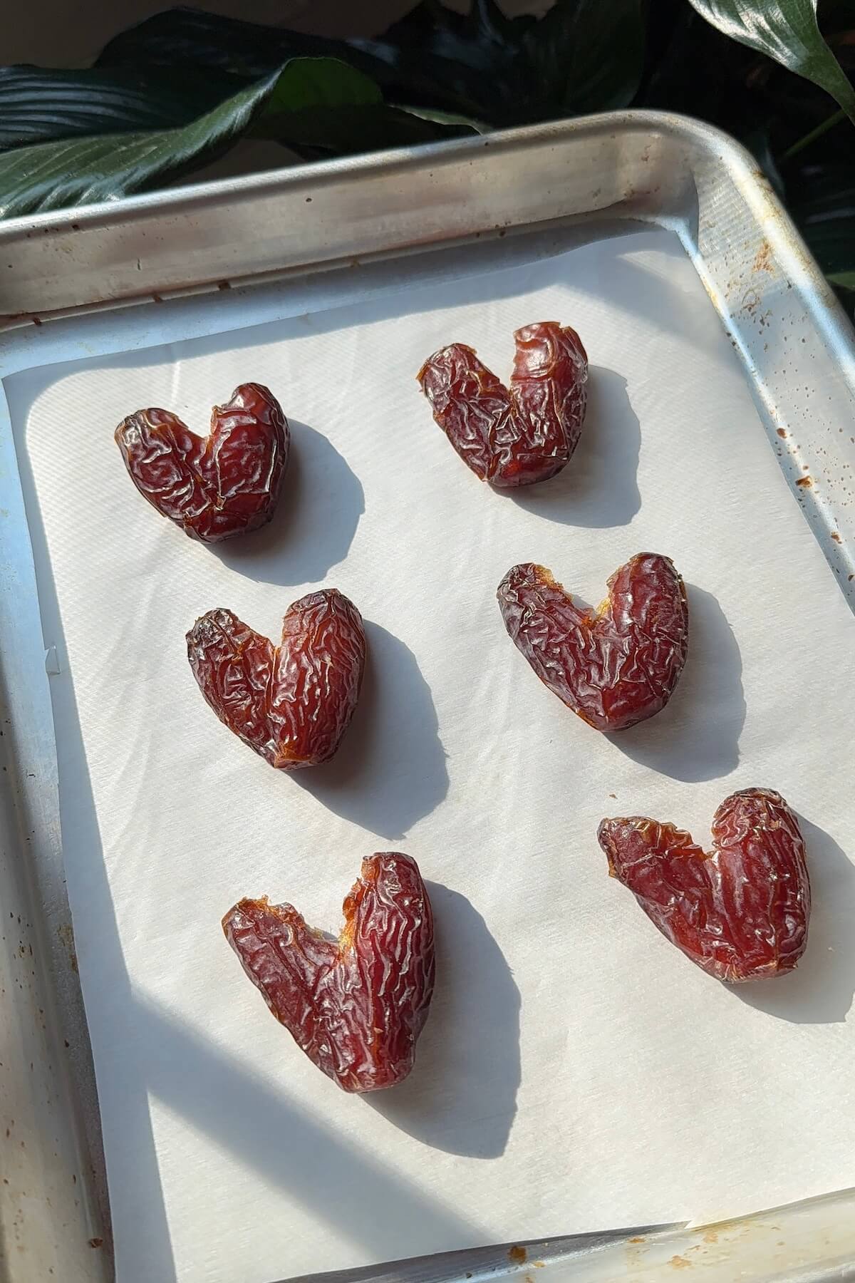 Shaping medjool dates into heart shapes before adding chocolate.