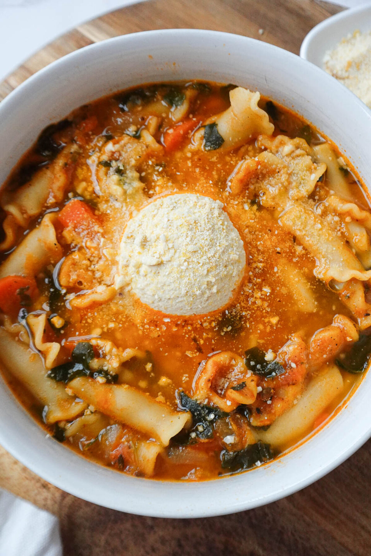 Comforting vegan lasagna soup topped with creamy tofu ricotta and a sprinkle of cashew parmesan.