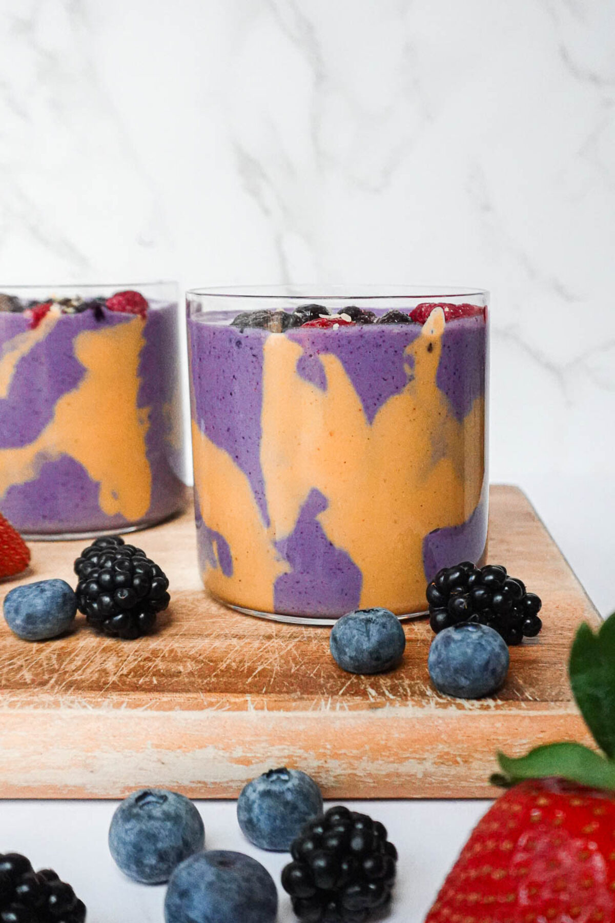 Peanut butter and jelly smoothie in a glass with peanut butter drizzle