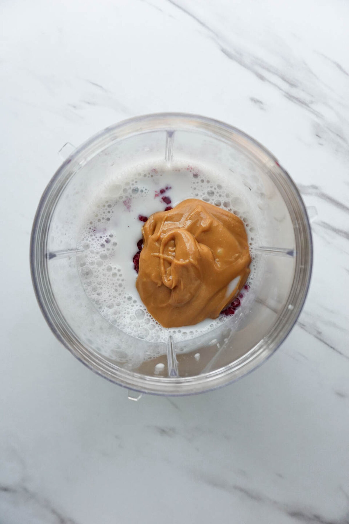 ingredients for peanut butter and jelly smoothie in a blender