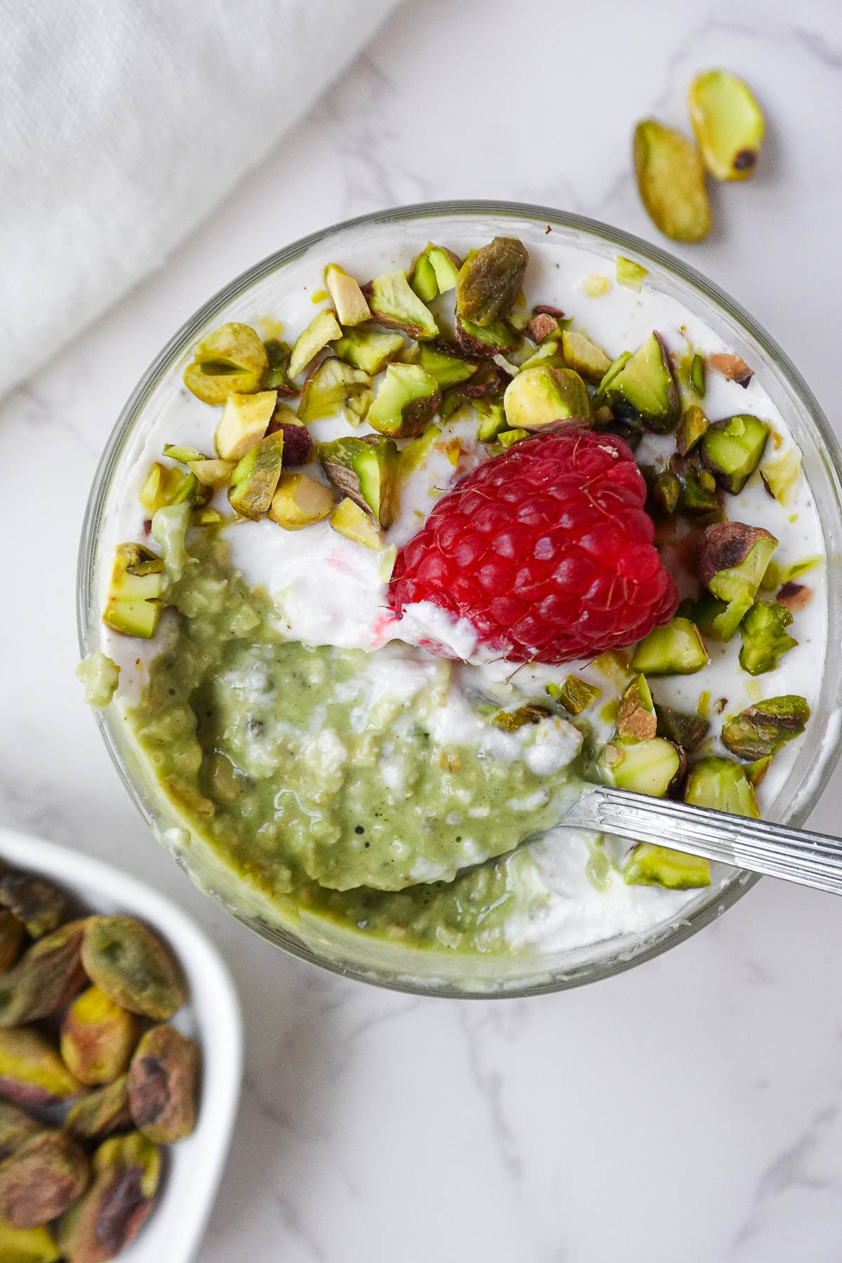 Spoonful of creamy pistachio overnight oats showing thick and creamy texture.
