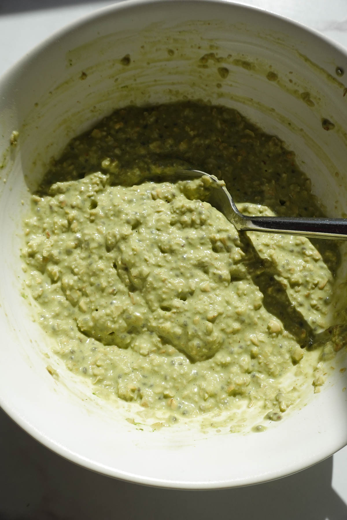 Pistachio overnight oats in a bowl after refrigerating, showing it's thick and creamy texture.