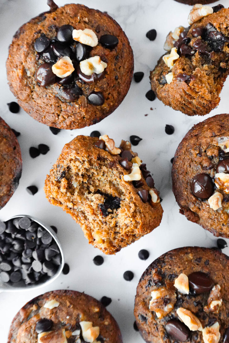 overhead shot of healthy banana muffins with a bite taken out showing it's fluffy texture