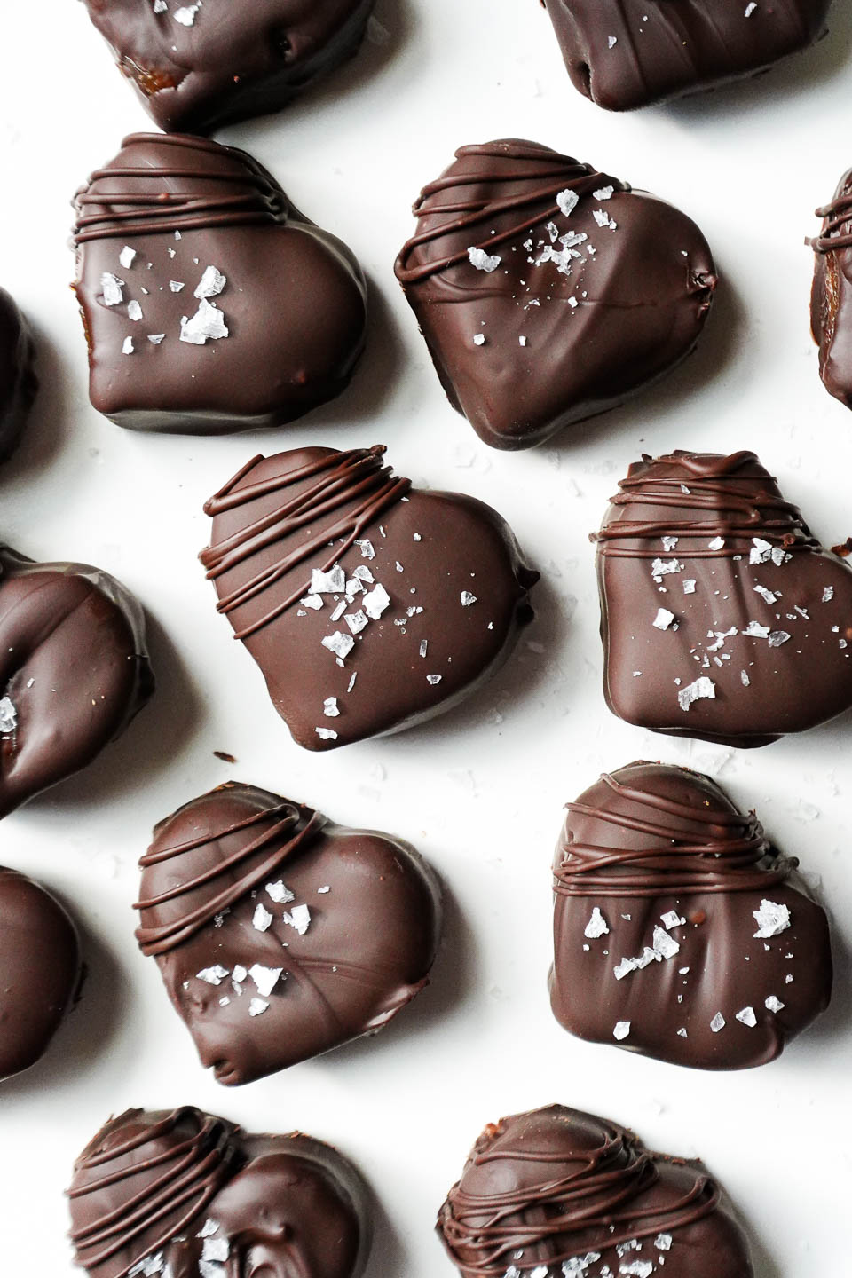 Healthy homemade chocolate caramels shaped like hearts and drizzled with chocolate, perfect for Valentine’s Day.