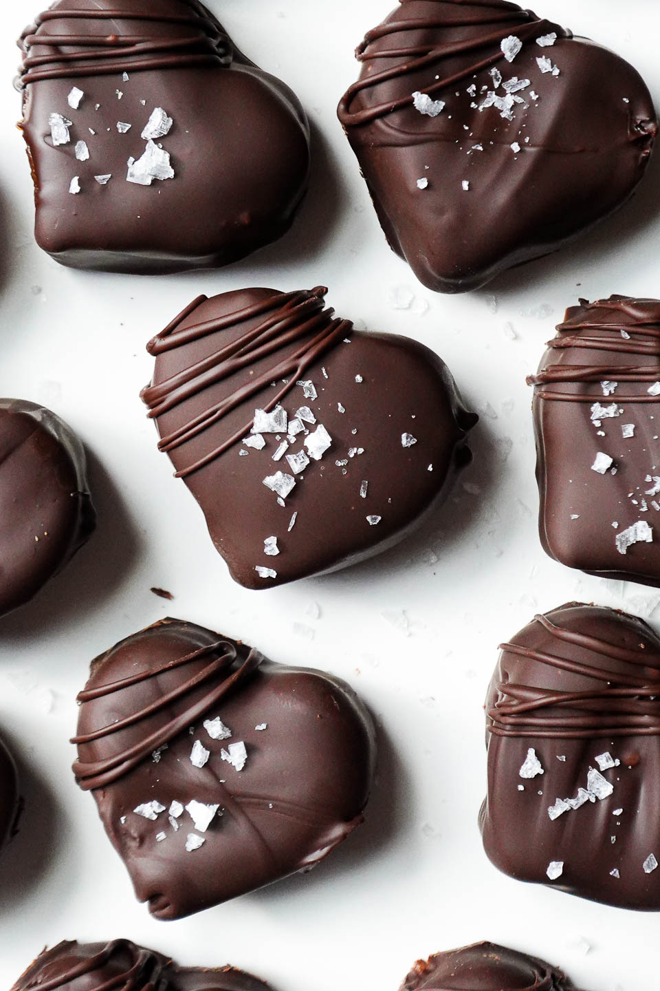 Heart-shaped chocolate date caramels dipped in rich chocolate and sprinkled with flaky sea salt.