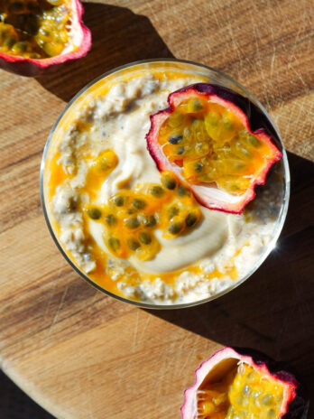 Overhead photo of tropical Mango & Passion Fruit Overnight Oats topped with a halved passionfruit