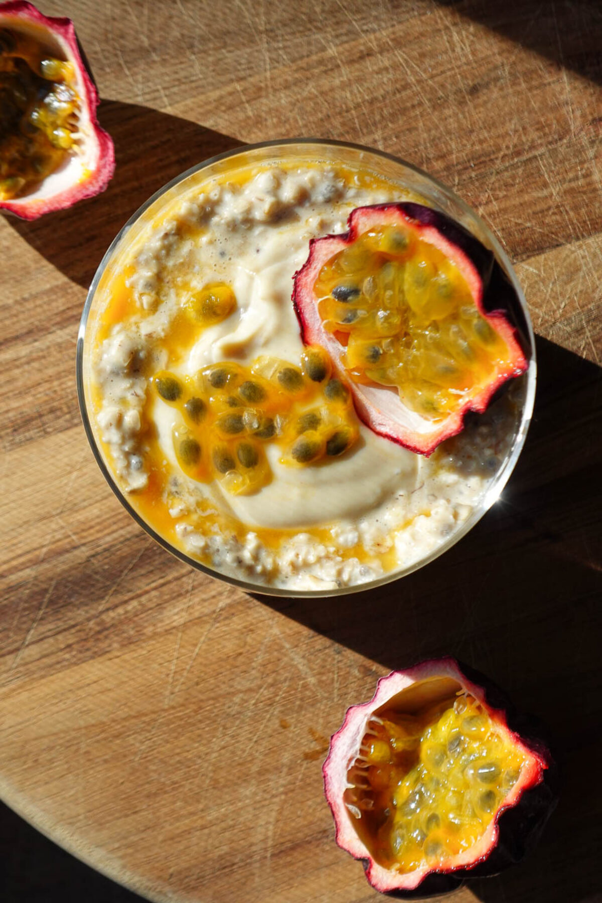 Overhead photo of tropical Mango & Passion Fruit Overnight Oats topped with a halved passionfruit