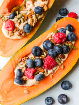 Papaya yogurt bowl filled with yogurt, topped with fresh fruit, and granola.