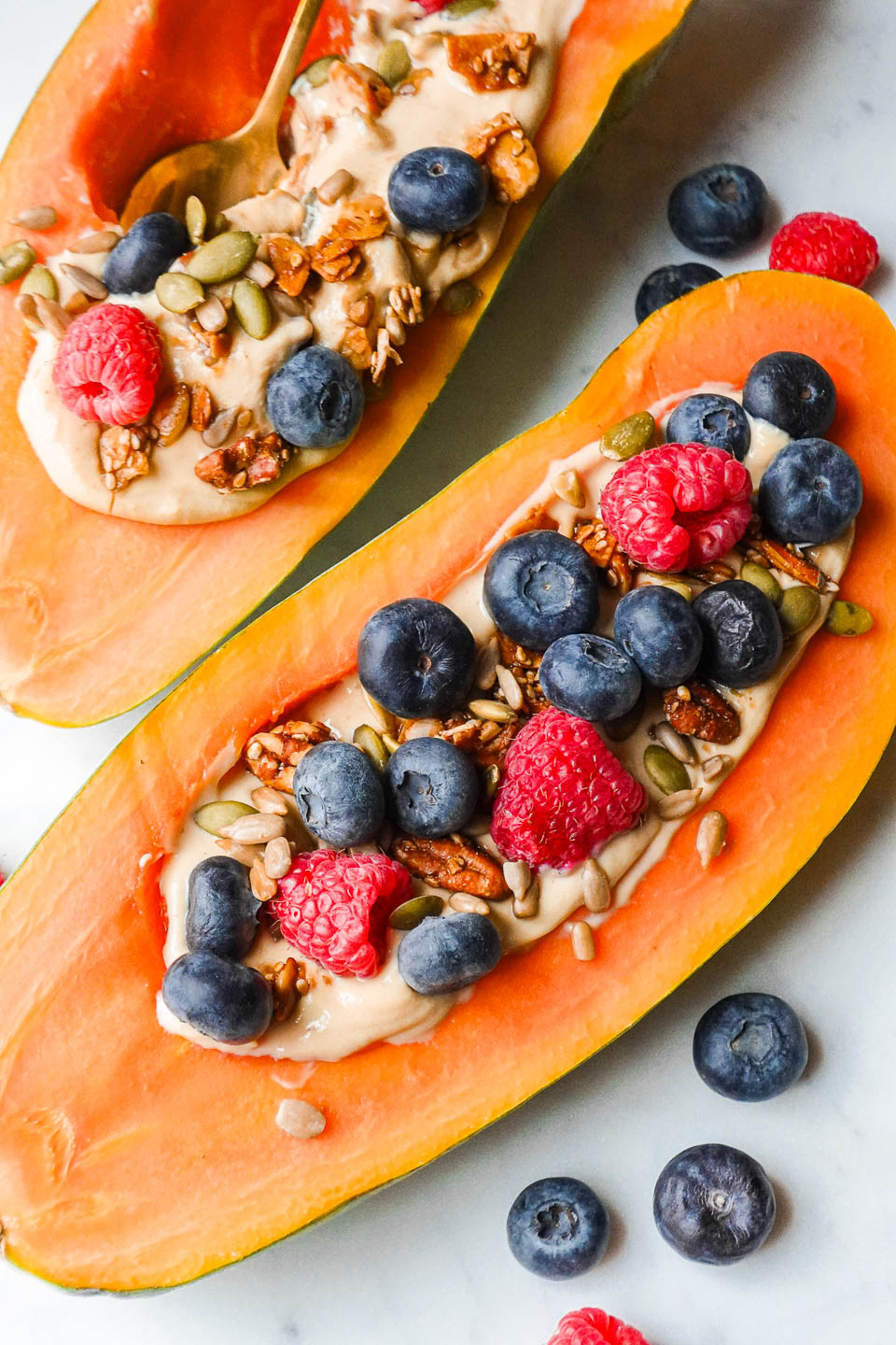 Papaya yogurt bowl filled with yogurt, topped with fresh fruit, and granola.