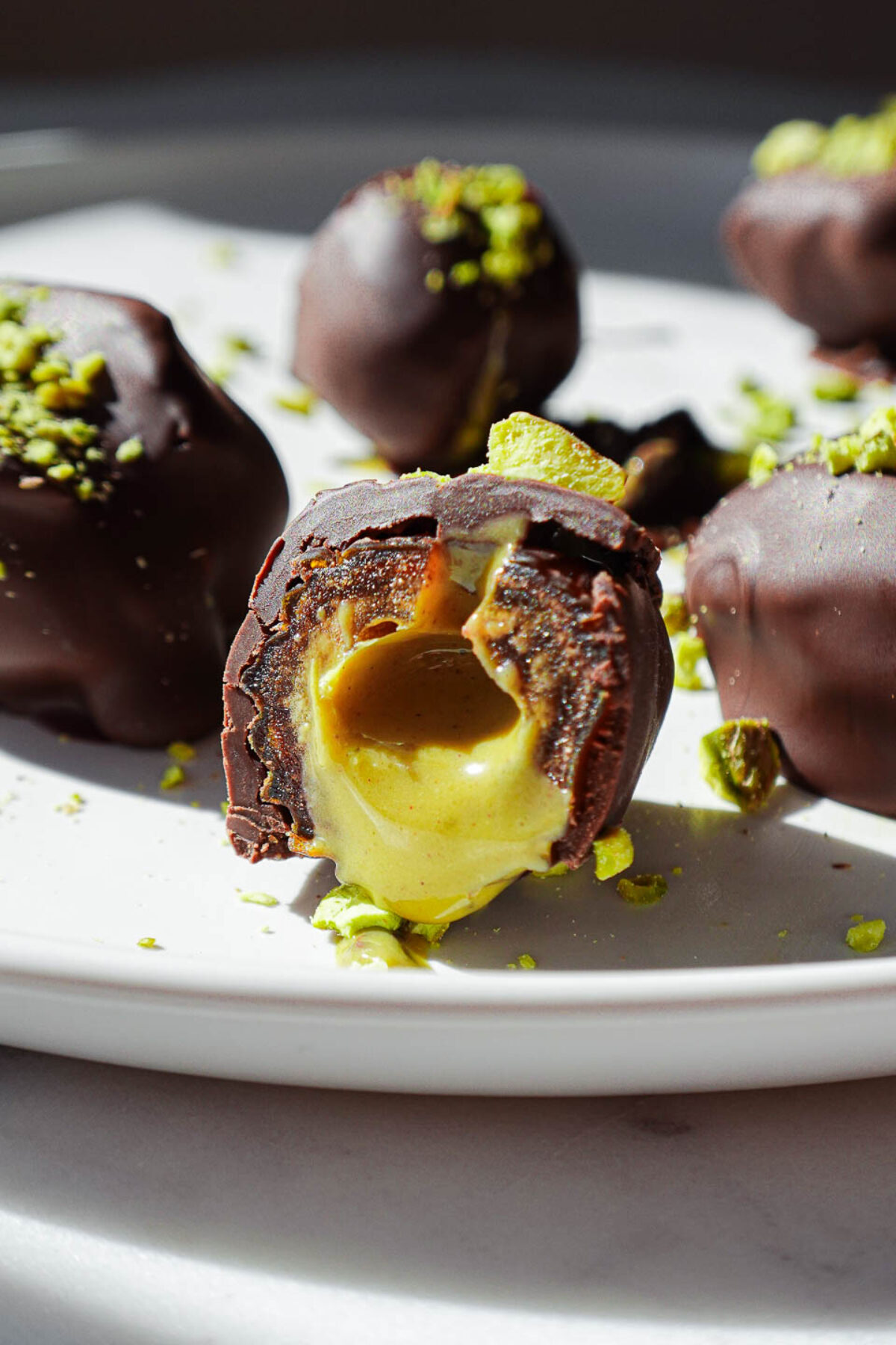 Pistachio stuffed date cut in half with pistachio butter dripping out
