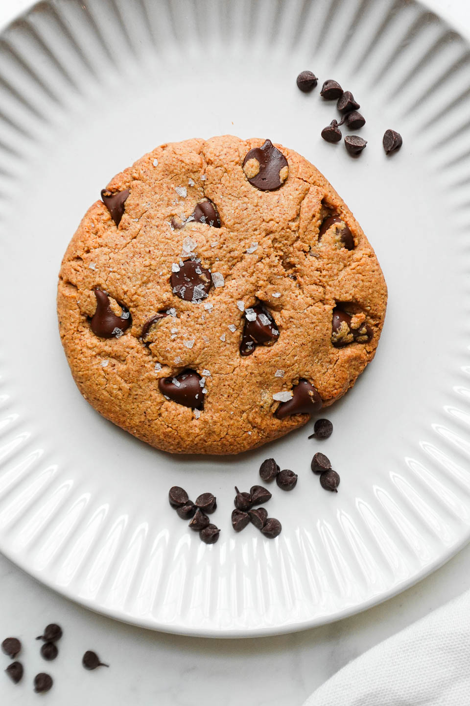 Close-up of a freshly baked single serve chocolate chip cookie with a gooey, melty chocolate center.
