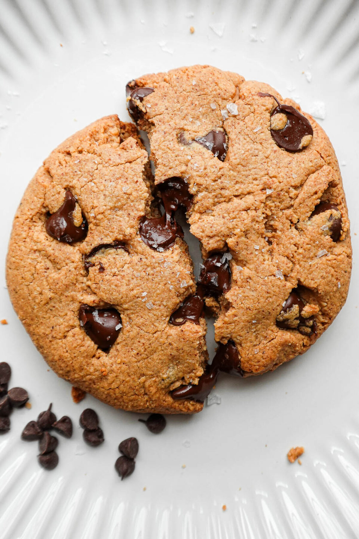 A warm, golden-brown cookie split open, with rich melted chocolate spilling out.