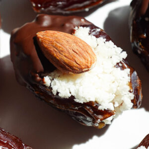 Close-up of chewy medjool dates stuffed with sweet coconut and coated in melted vegan chocolate