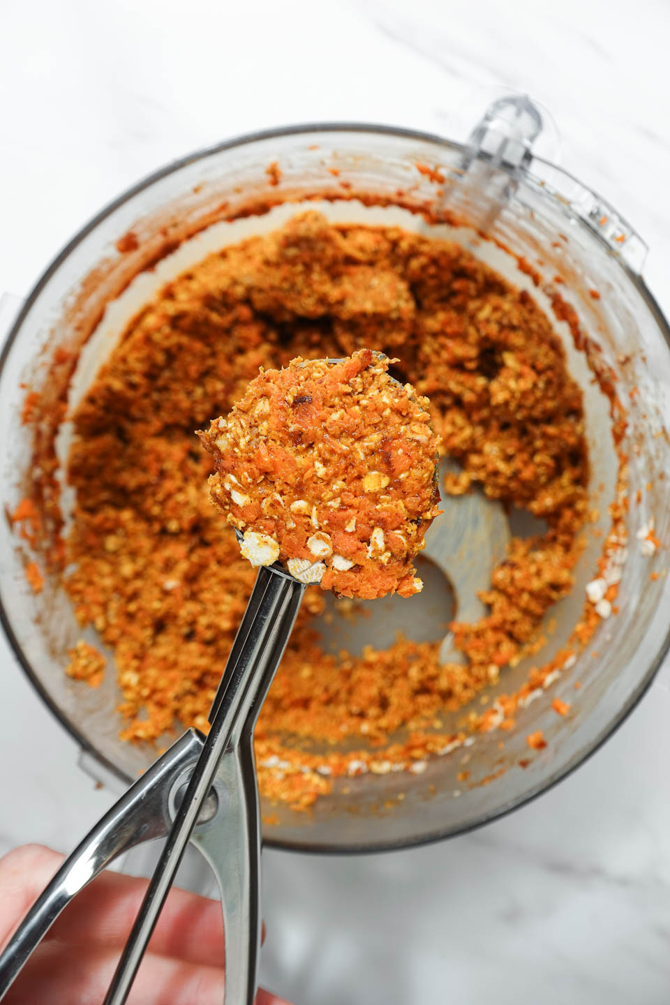 scooping energy ball mixture after blending in food processor