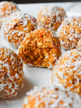 Soft carrot cake energy ball with. bite taken out showing chewy, soft texture inside