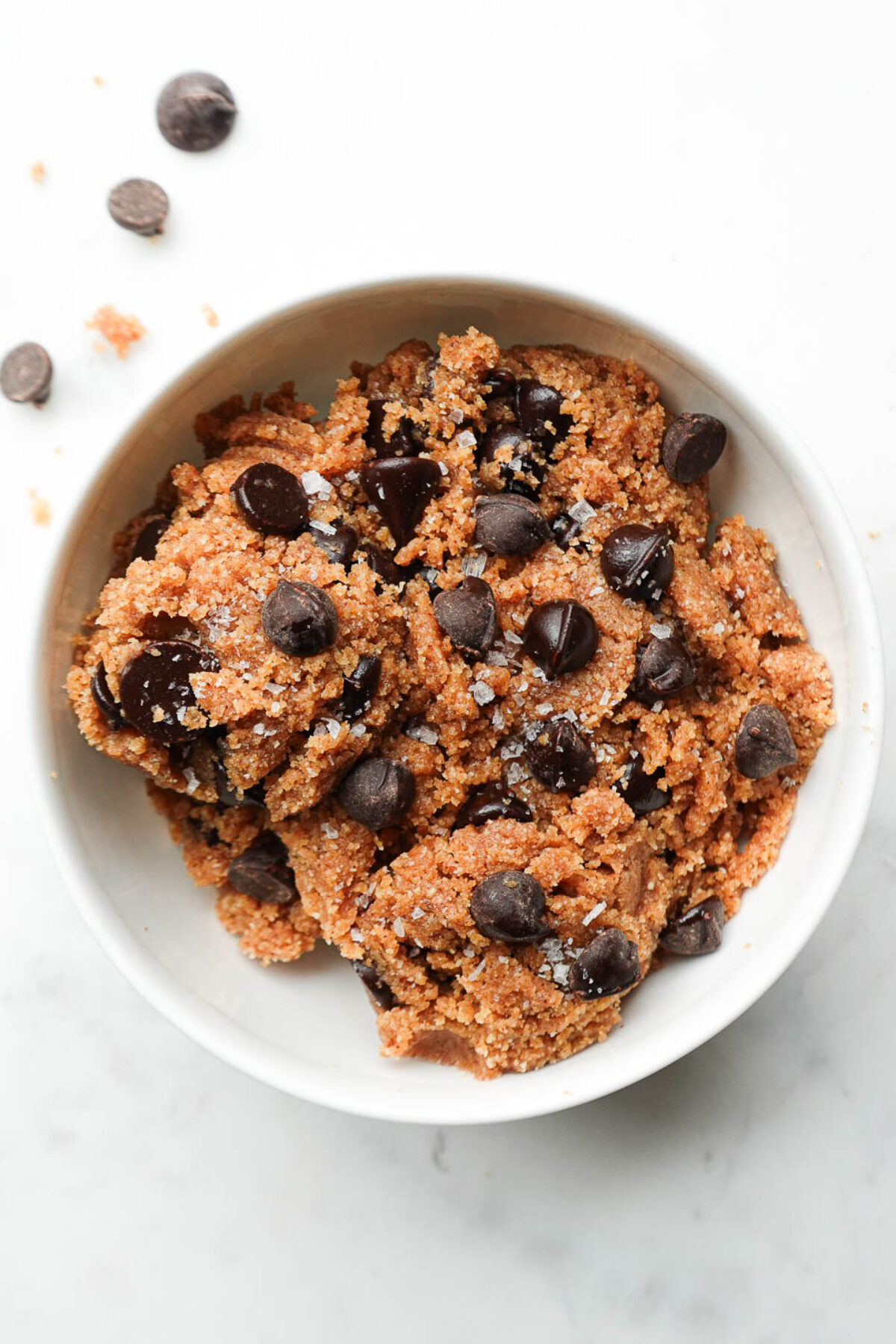 Healthy edible cookie dough made with almond flour, almond butter, and chocolate chips in a bowl.