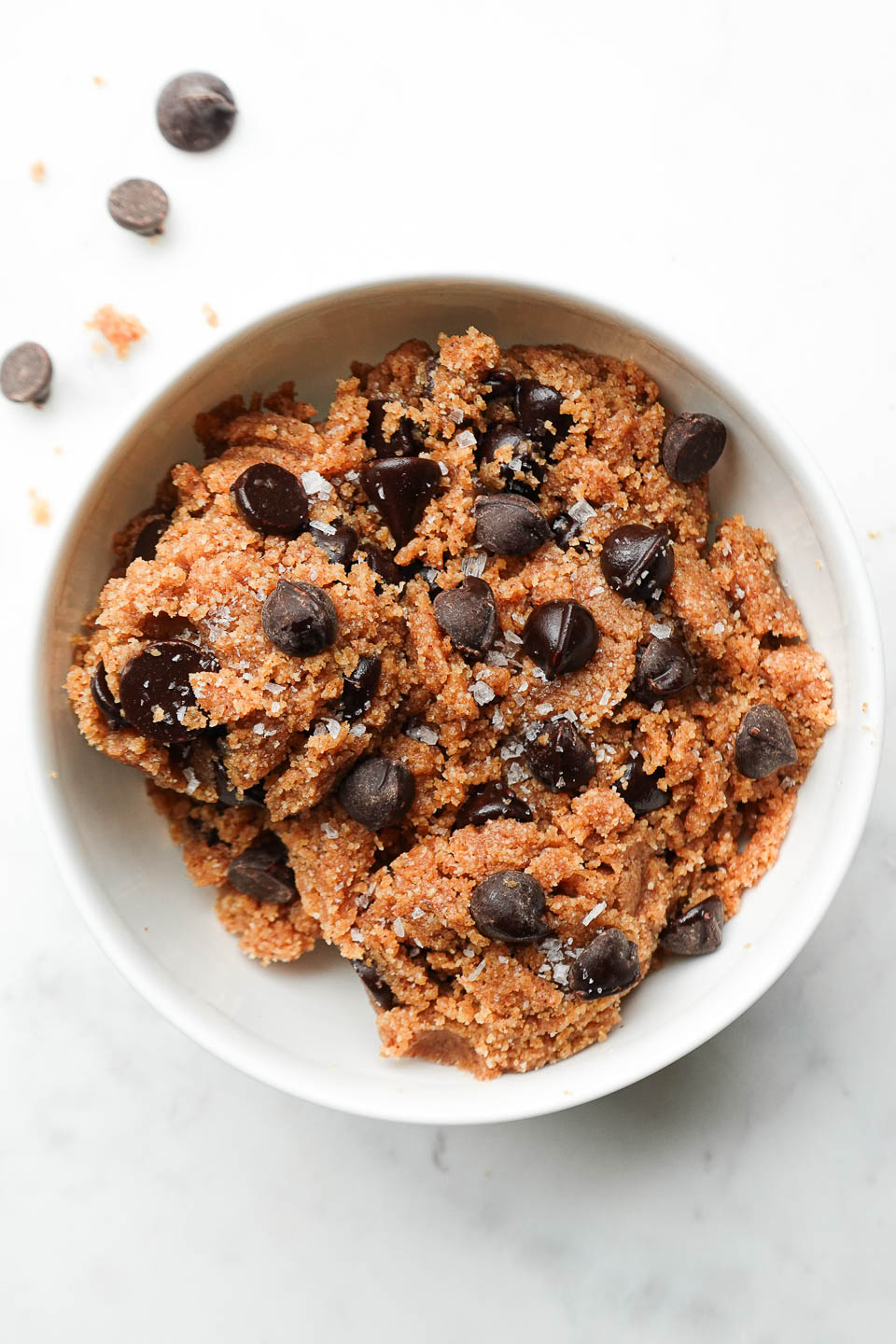 Healthy edible cookie dough made with almond flour, almond butter, and chocolate chips in a bowl.