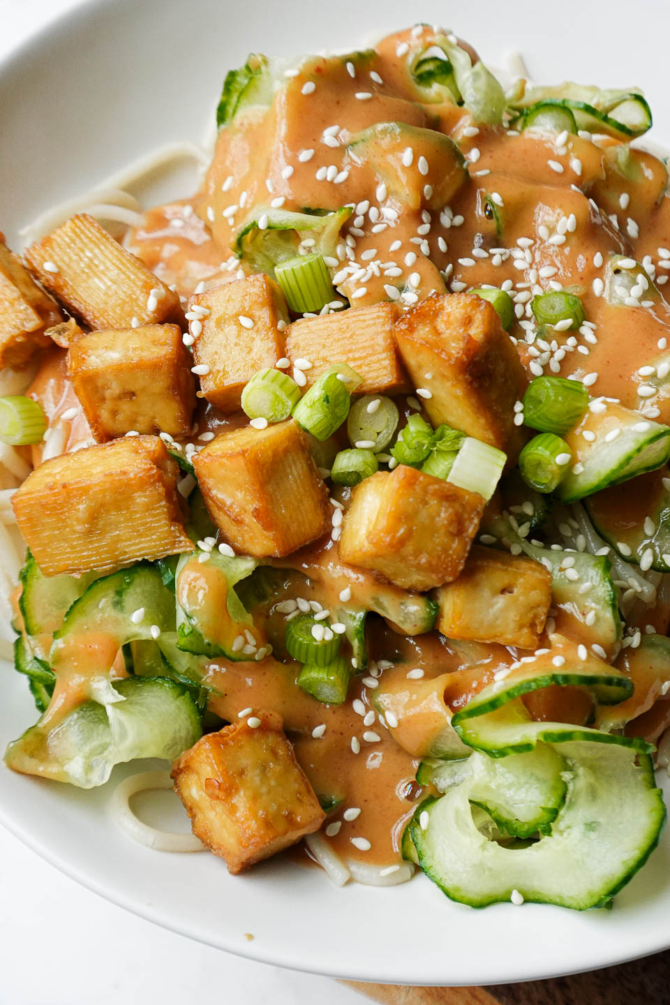 Colorful vegan noodle bowl with brown rice noodles, tofu, and fresh vegetables