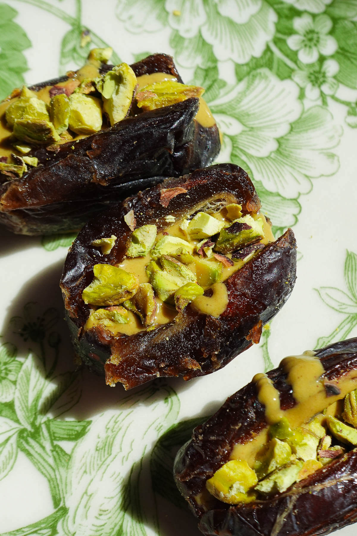Filling dates with chopped pistachios to make pistachio stuffed dates.