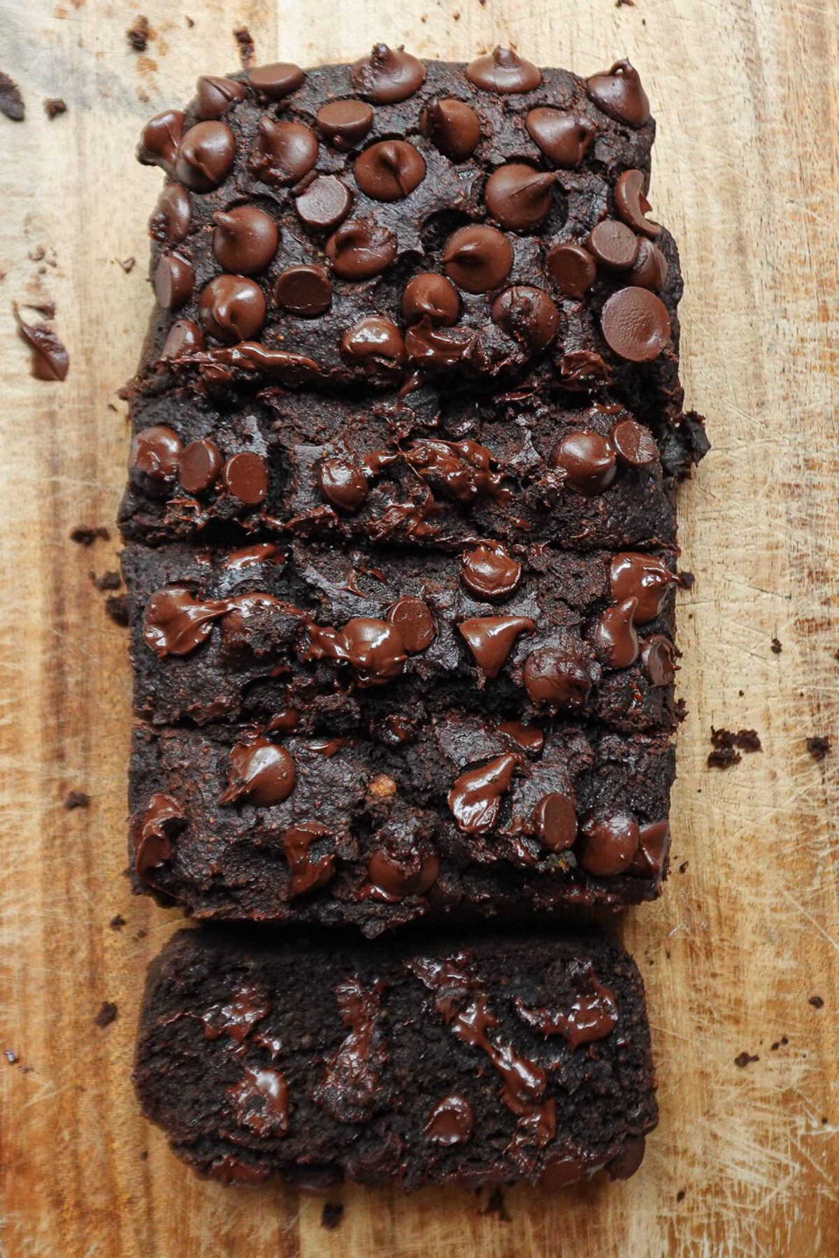Overhead view of sliced healthy chocolate banana bread with melty chocolate chips and a fluffy texture.