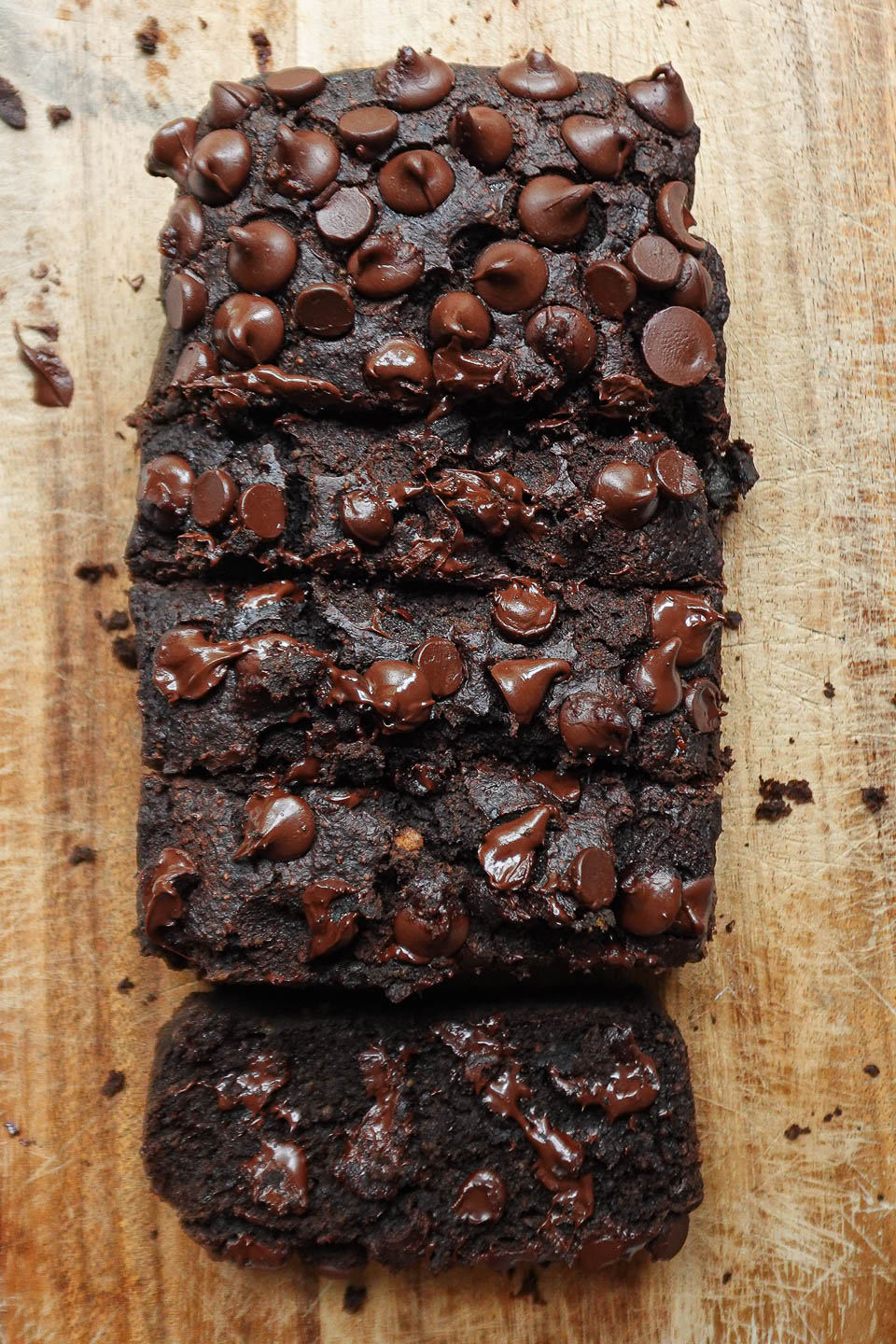 Overhead view of sliced healthy chocolate banana bread with melty chocolate chips and a fluffy texture.