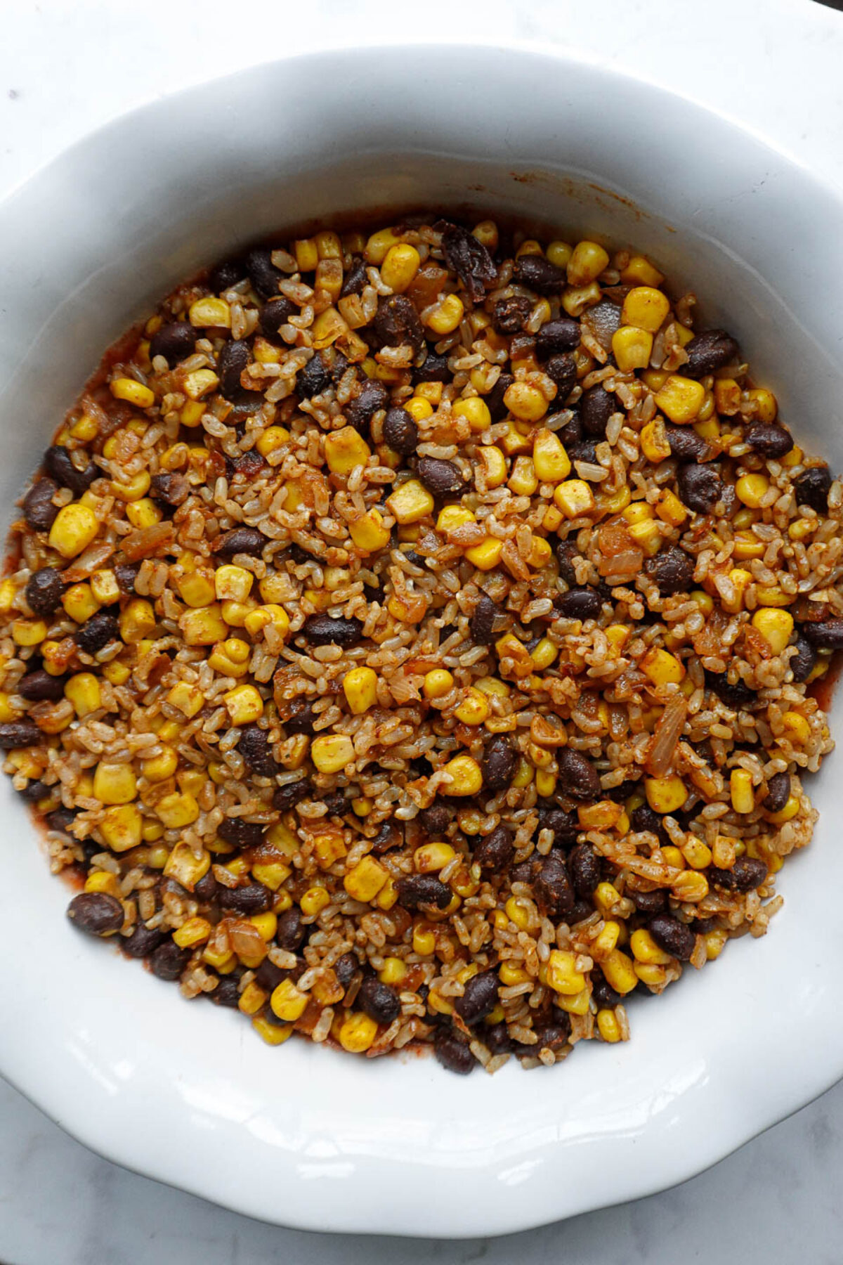 Half of the rice and bean mixture added over the salsa layer in the baking dish