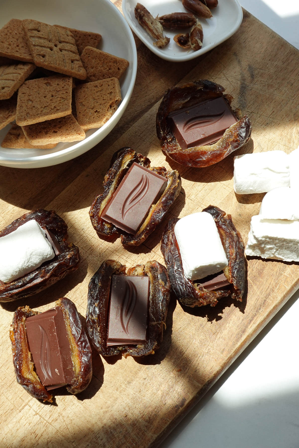Medjool dates sliced open and filled with chocolate and marshmallows to make s'mores stuffed dates.