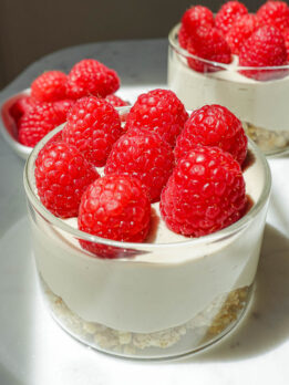 Fresh, juicy raspberries topping vegan raspberry cheesecake jars, adding a vibrant pop of color