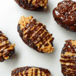 Vegan Samoas stuffed dates made with dates, chocolate, and coconut on a serving plate