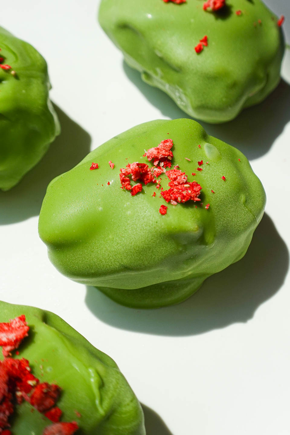 strawberry matcha stuffed date with creamy strawberry yogurt filling and green matcha coating