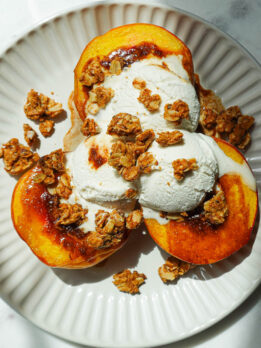 Air fryer peaches topped with vegan vanilla ice cream and granola