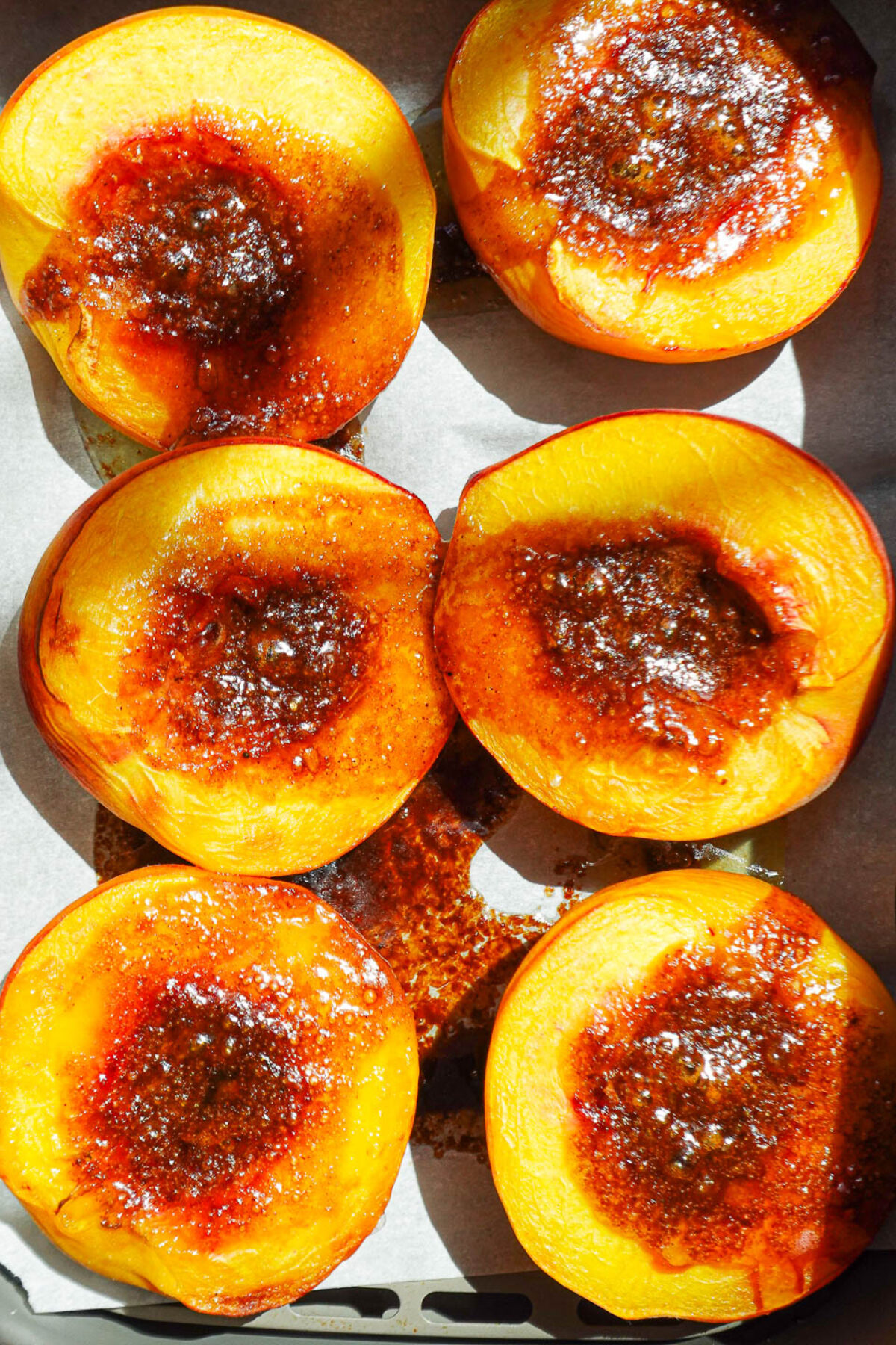 Close-up of caramelized air fryer peach halves with cinnamon sugar topping